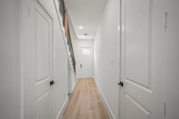 a view of a hallway with wooden floor and entryway