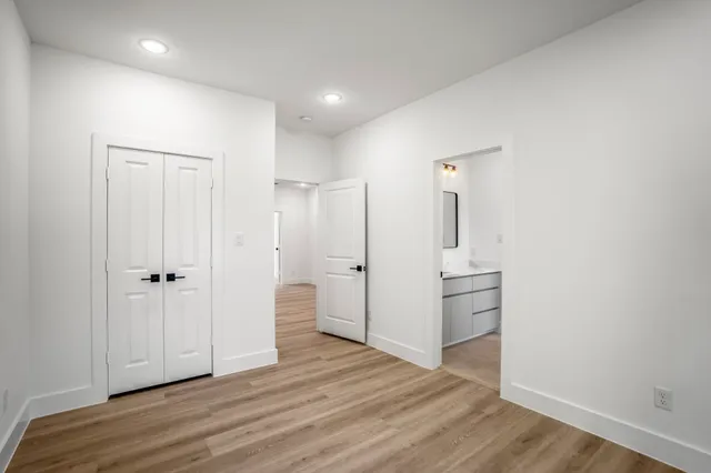 an empty room with wooden floor and cabinet