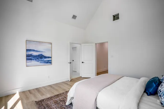 a bedroom with a bed and a painting on the wall