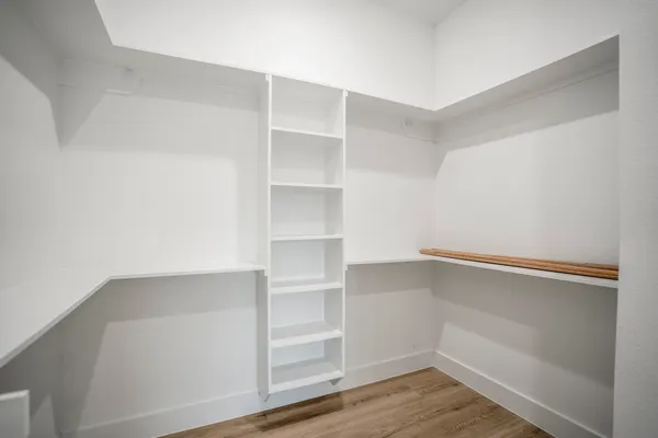a view of walk in closet with empty racks