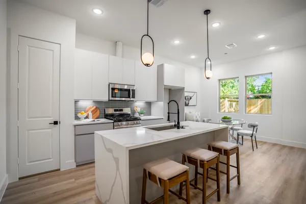 a kitchen with a table chairs refrigerator and microwave