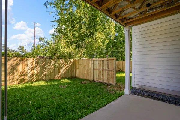a view of a backyard with barn plants and large tree