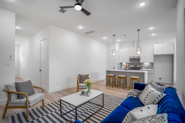 a living room with furniture and kitchen view