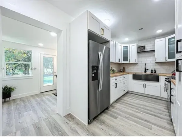 a kitchen with stainless steel appliances a refrigerator sink and cabinets