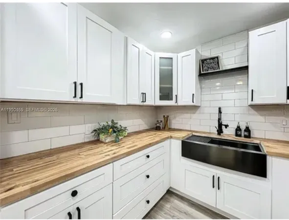 a kitchen with stainless steel appliances white cabinets sink and stove