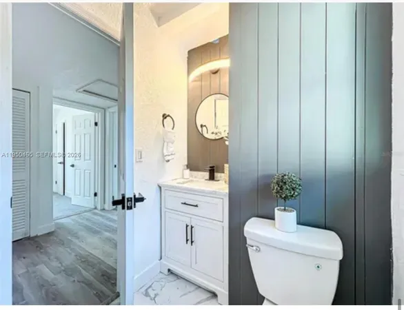 a bathroom with a toilet a sink and mirror