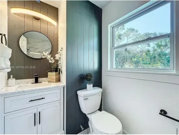 a bathroom with a toilet a sink and a mirror
