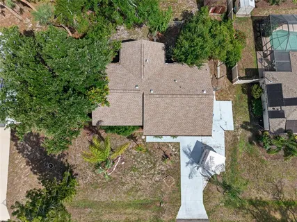 an aerial view of a house with yard and swimming pool