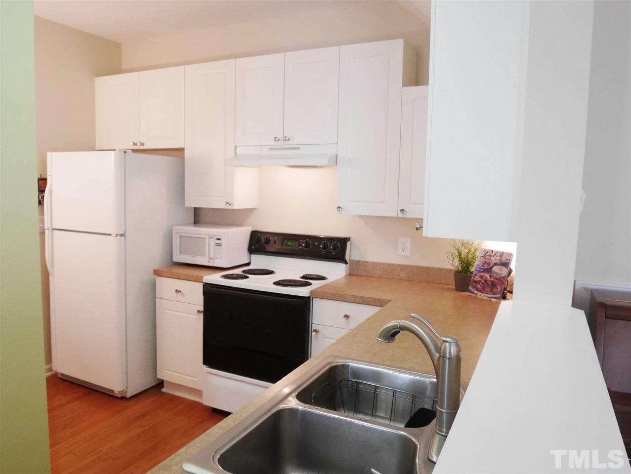 2016 Metacomet Way Raleigh, NC 27604 - Photo 6 of 24 a kitchen with a refrigerator sink stove and white cabinets