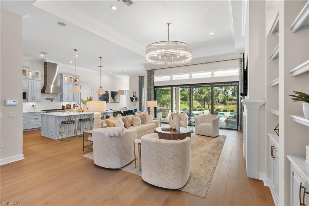 15266 Arpino Court Naples, FL 34114 - Photo 10 of 48 a large room with stainless steel appliances kitchen island granite countertop furniture a large window and a chandelier