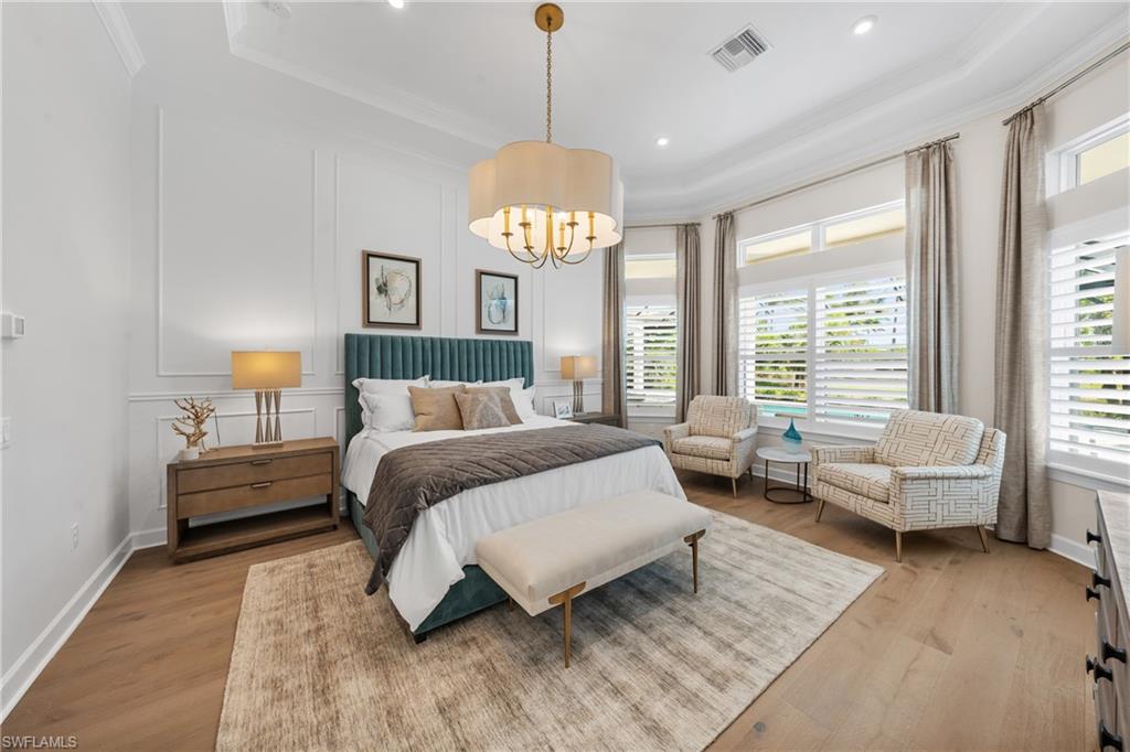15266 Arpino Court Naples, FL 34114 - Photo 17 of 48 a spacious bedroom with a bed and a chandelier