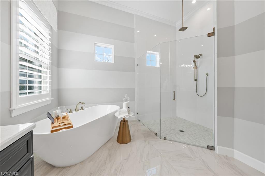 15266 Arpino Court Naples, FL 34114 - Photo 19 of 48 a bathroom with a tub a window and glass door shower