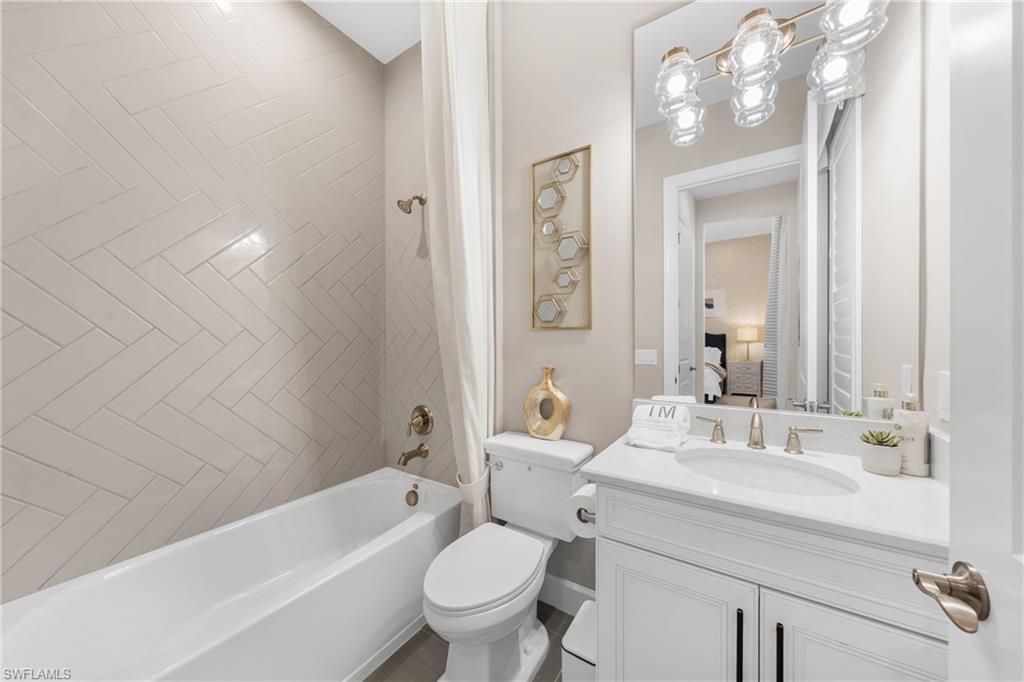 15266 Arpino Court Naples, FL 34114 - Photo 21 of 48 a bathroom with a toilet a sink a mirror a bathtub and vanity