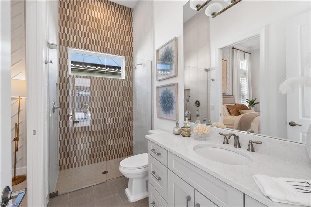15266 Arpino Court Naples, FL 34114 - Photo 23 of 48 a bathroom with a sink toilet vanity and shower
