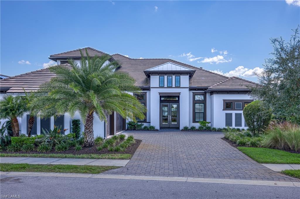 15266 Arpino Court Naples, FL 34114 - Photo 3 of 48 a front view of a house with a garden