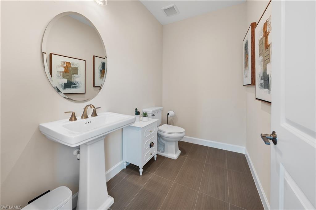 15266 Arpino Court Naples, FL 34114 - Photo 32 of 48 a bathroom with a toilet a sink and mirror