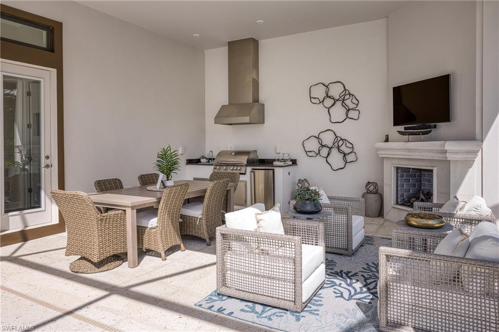 15266 Arpino Court Naples, FL 34114 - Photo 40 of 48 a living room with fireplace furniture and a flat screen tv