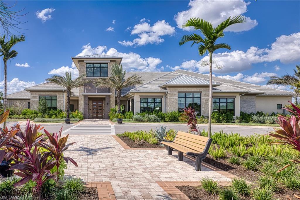 15266 Arpino Court Naples, FL 34114 - Photo 45 of 48 a front view of a house with a porch and a yard