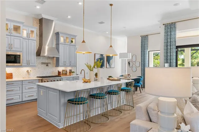 a open kitchen with stainless steel appliances kitchen island granite countertop a stove a sink a dining table and chairs