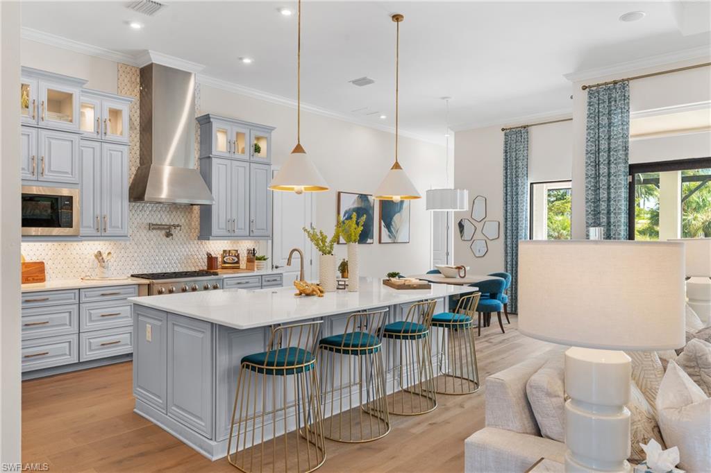 15266 Arpino Court Naples, FL 34114 - Photo 6 of 48 a open kitchen with stainless steel appliances kitchen island granite countertop a stove a sink a dining table and chairs