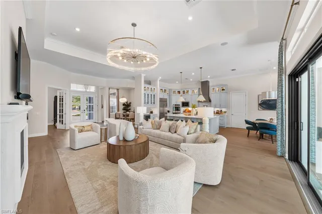a large white kitchen with a large window and stainless steel appliances