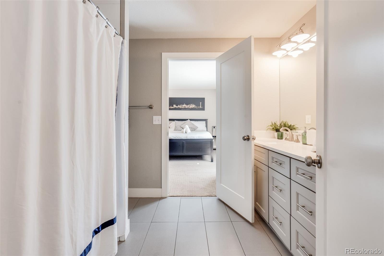 5240 Stuart Street Denver, CO 80212 - Photo 19 of 42 a bathroom with a double vanity sink a toilet and a mirror
