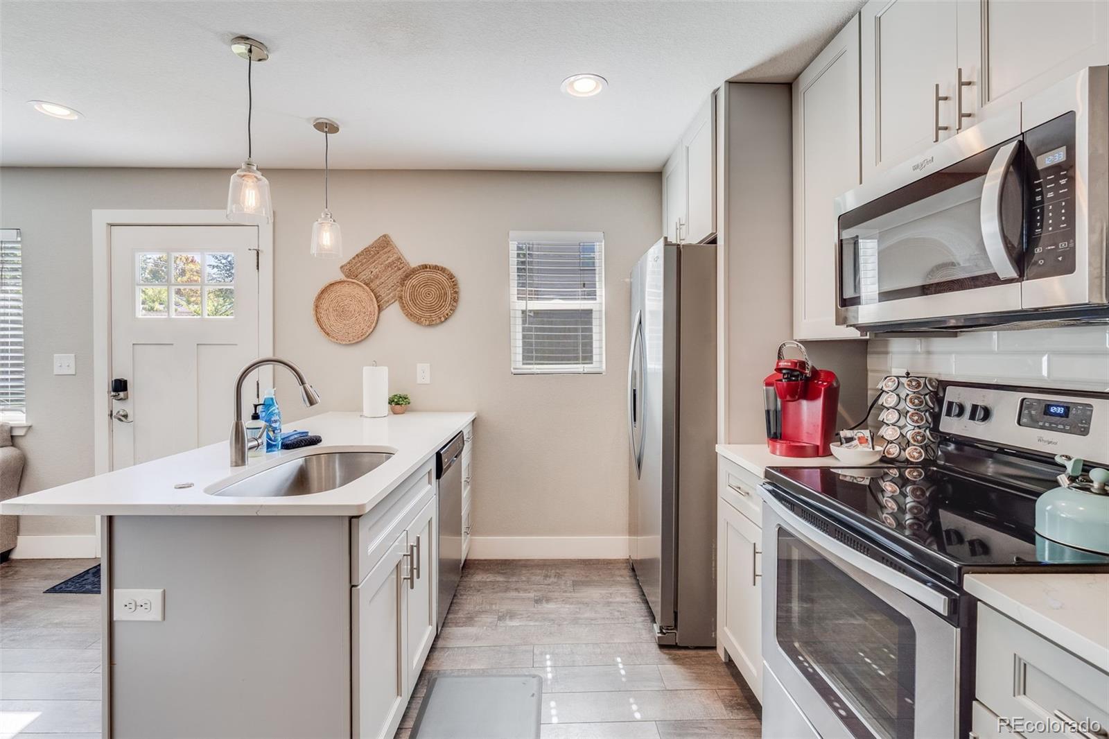 5240 Stuart Street Denver, CO 80212 - Photo 26 of 42 a kitchen with a sink cabinets and stainless steel appliances