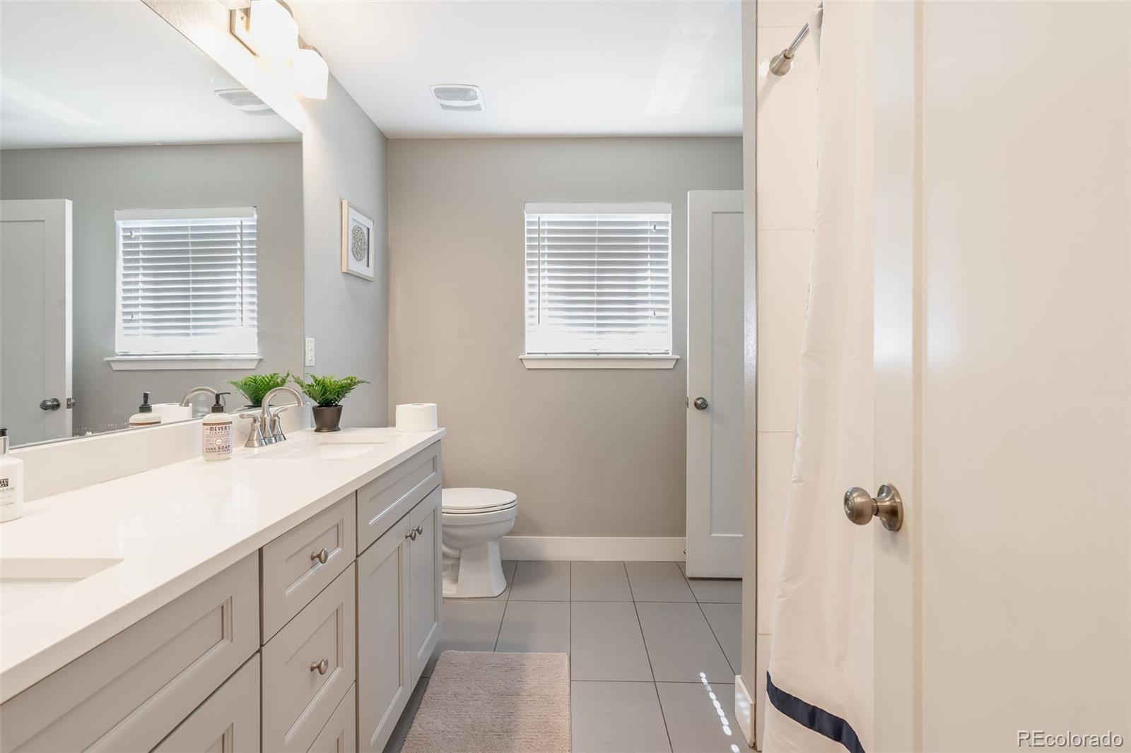 5240 Stuart Street Denver, CO 80212 - Photo 29 of 42 a bathroom with a sink a toilet and shower