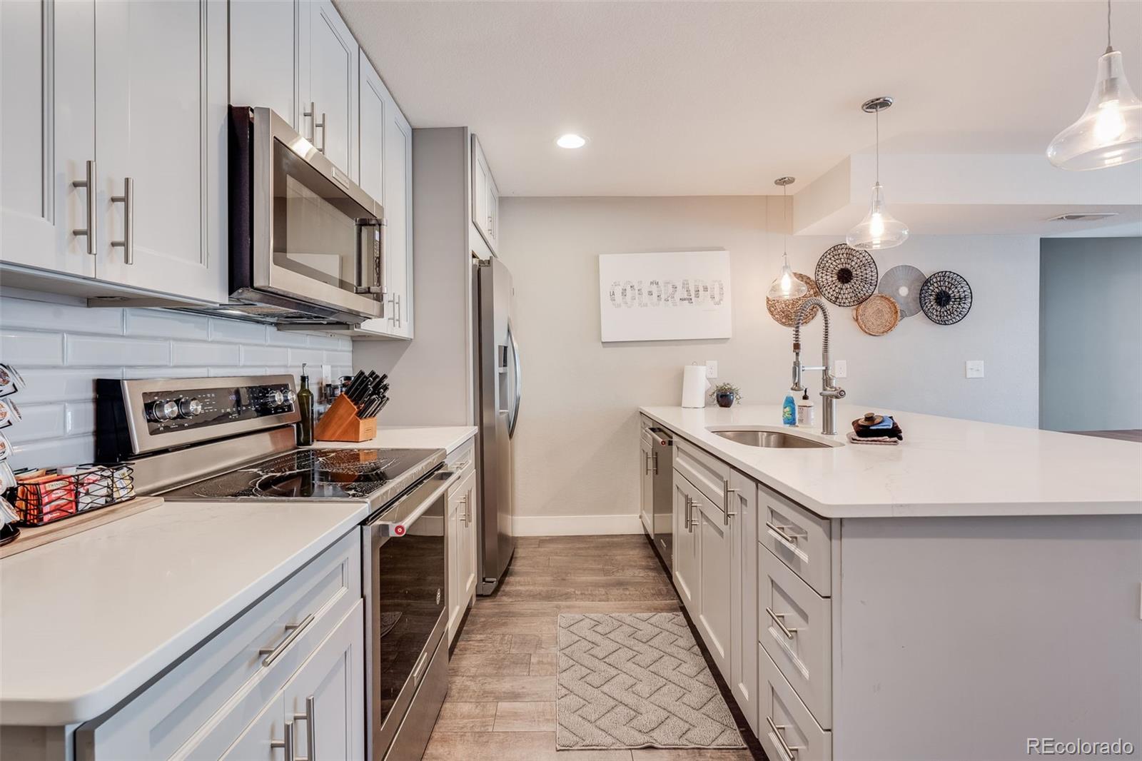 5240 Stuart Street Denver, CO 80212 - Photo 8 of 42 a kitchen with a sink stove and microwave