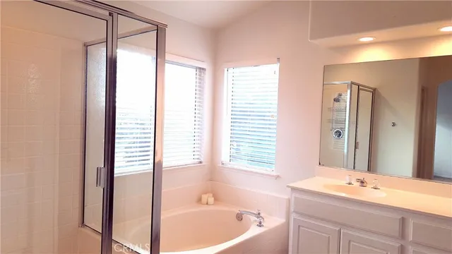 a bathroom with a tub sink and mirror