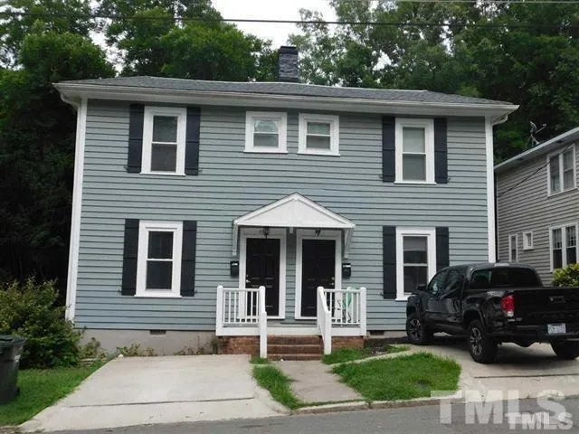 a front view of a house with a yard and potted plants