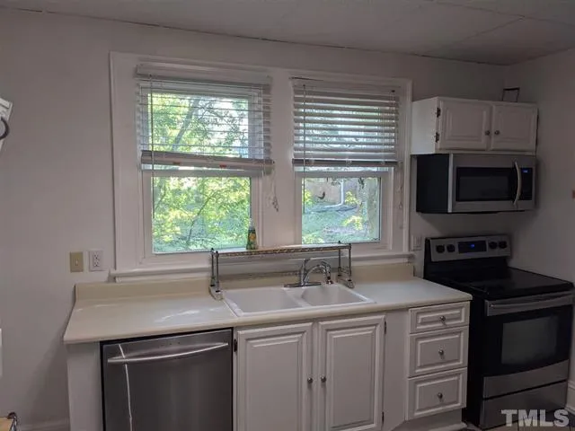 a kitchen with stainless steel appliances a sink stove and microwave