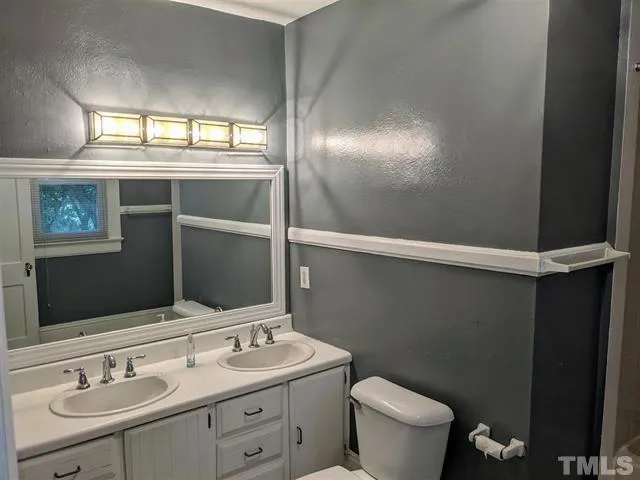 a bathroom with a sink and mirror with toilet