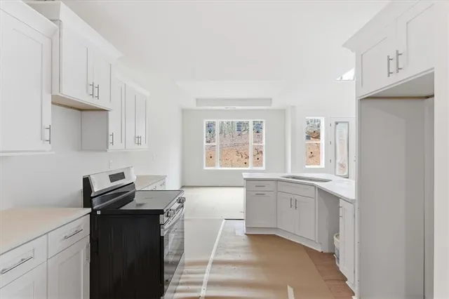 a kitchen with granite countertop white cabinets and white appliances