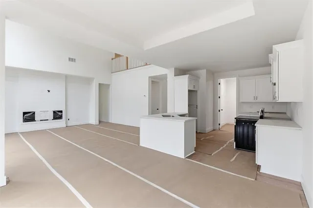 a kitchen with a refrigerator and white cabinets