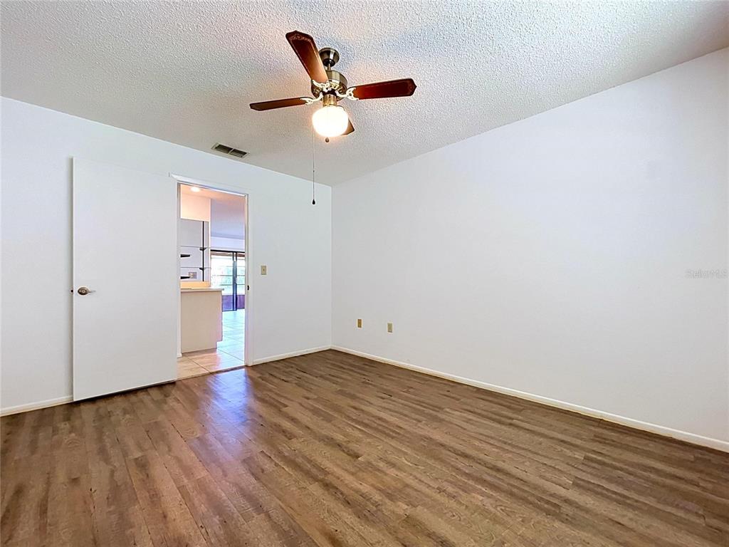 9319 Trowbridge Court New Port Richey, FL 34655 - Photo 51 of 78 an empty room with wooden floor and ceiling fan
