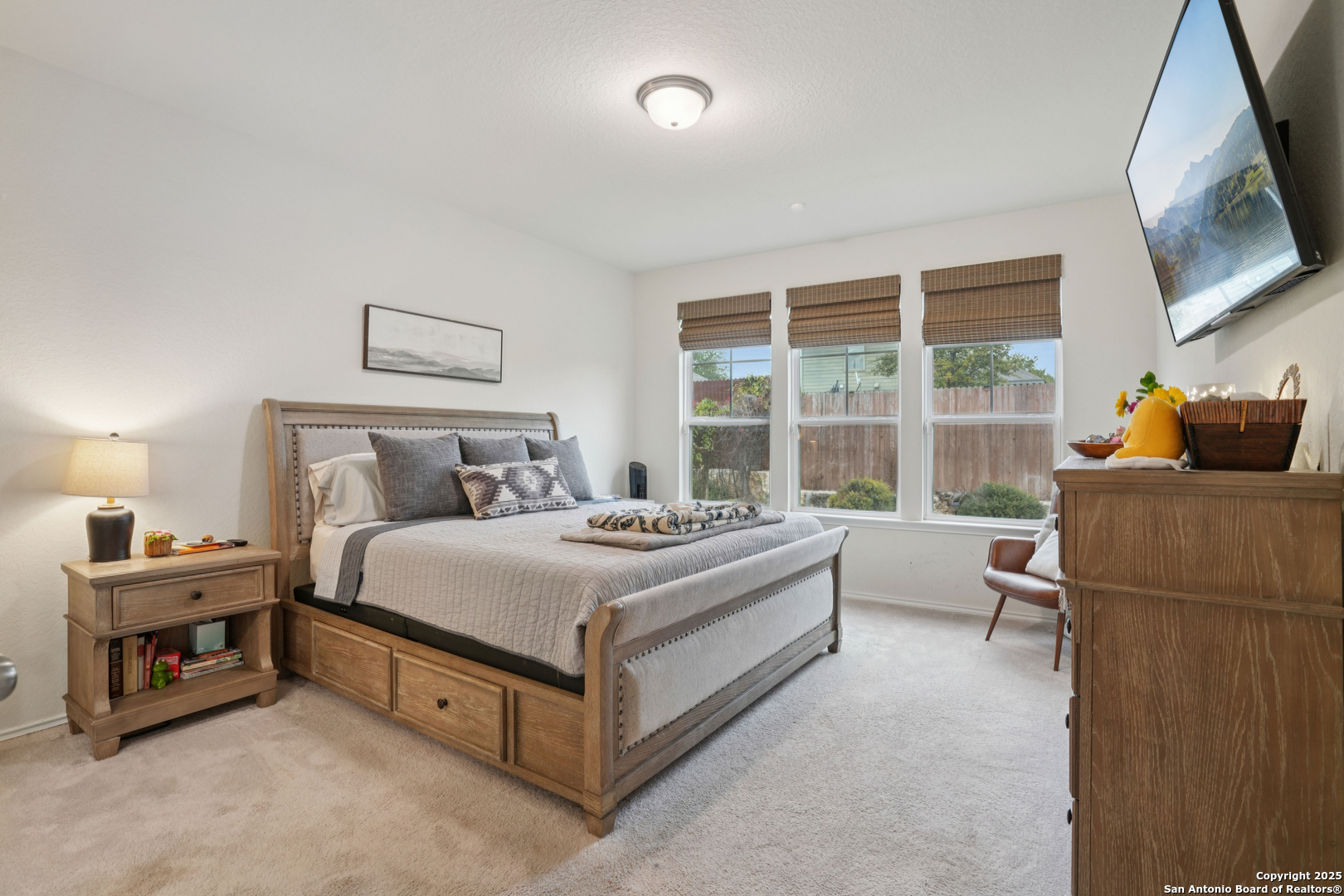 9028 Curling Post Schertz, TX 78154 - Photo 18 of 37 a bedroom with a bed and a flat tv screen on the dresser