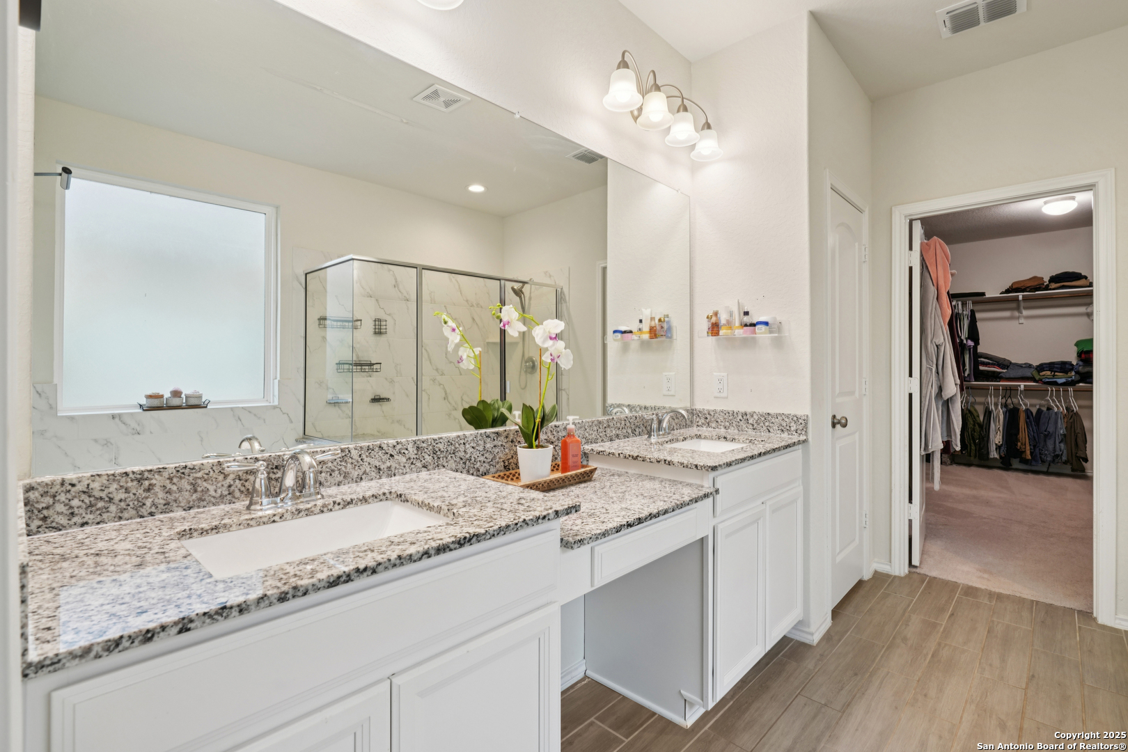 9028 Curling Post Schertz, TX 78154 - Photo 19 of 37 a bathroom with double vanity sinks a vanity a mirror and a shower