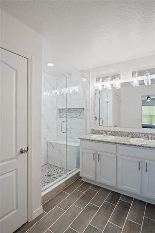 a spacious bathroom with a mirror a shower and a sink
