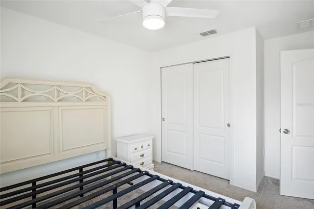 a bedroom with a bed and a chandelier fan