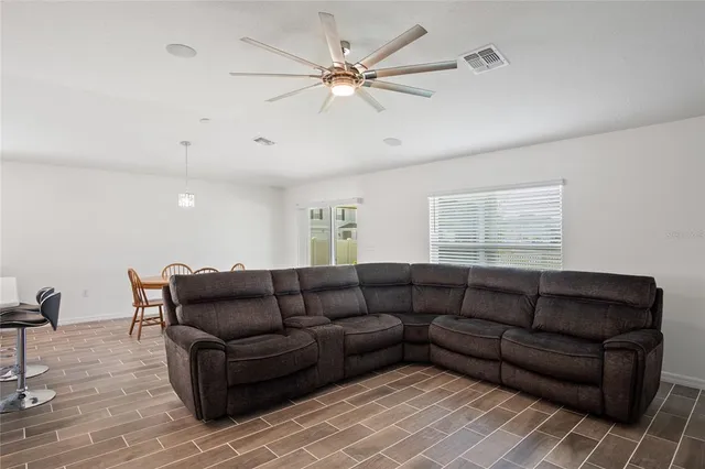 a living room with furniture and a ceiling fan