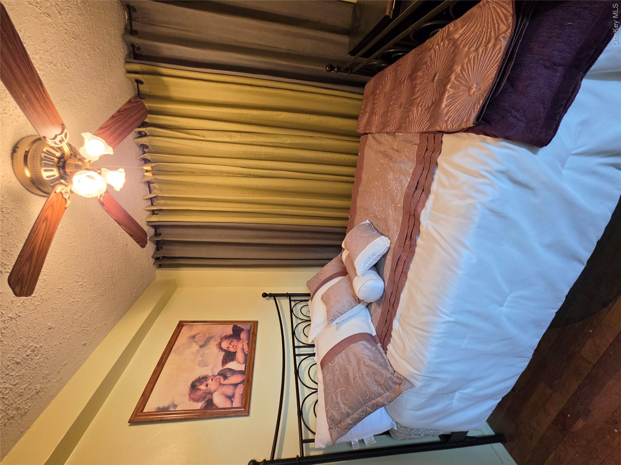 129 Beach 118th Street, Unit 5A Queens, NY 11694 - Photo 8 of 17 a bedroom with a bed and a chandelier