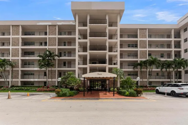 a front view of a building with a garden and plants