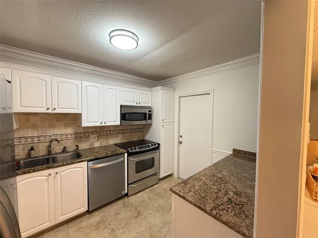a kitchen with stainless steel appliances granite countertop a stove and a sink
