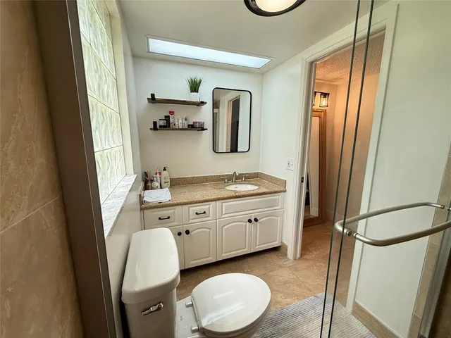 a spacious bathroom with a granite countertop sink and a mirror