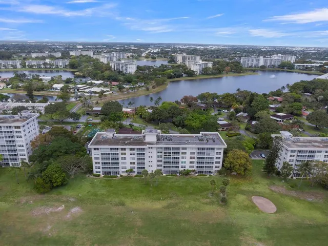 an aerial view of a city with lots of residential buildings ocean and mountain view in back