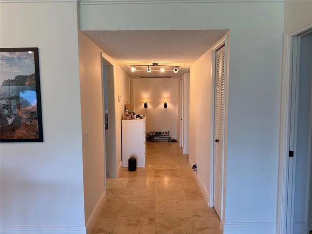 a view of a hallway with wooden floor and a living room
