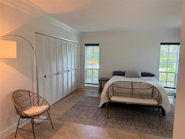 a bedroom with a bed chair and a window