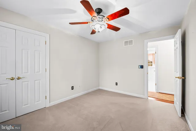 an empty room with closet and fan