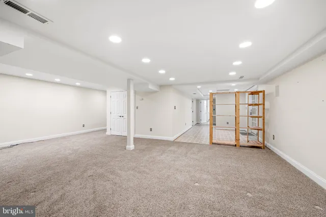 an empty room with windows and refrigerator